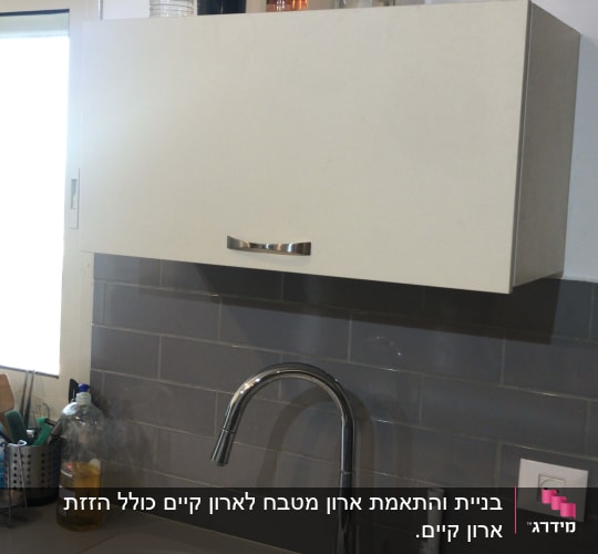 מטבח עם כיור, ברז וכלים על השיש